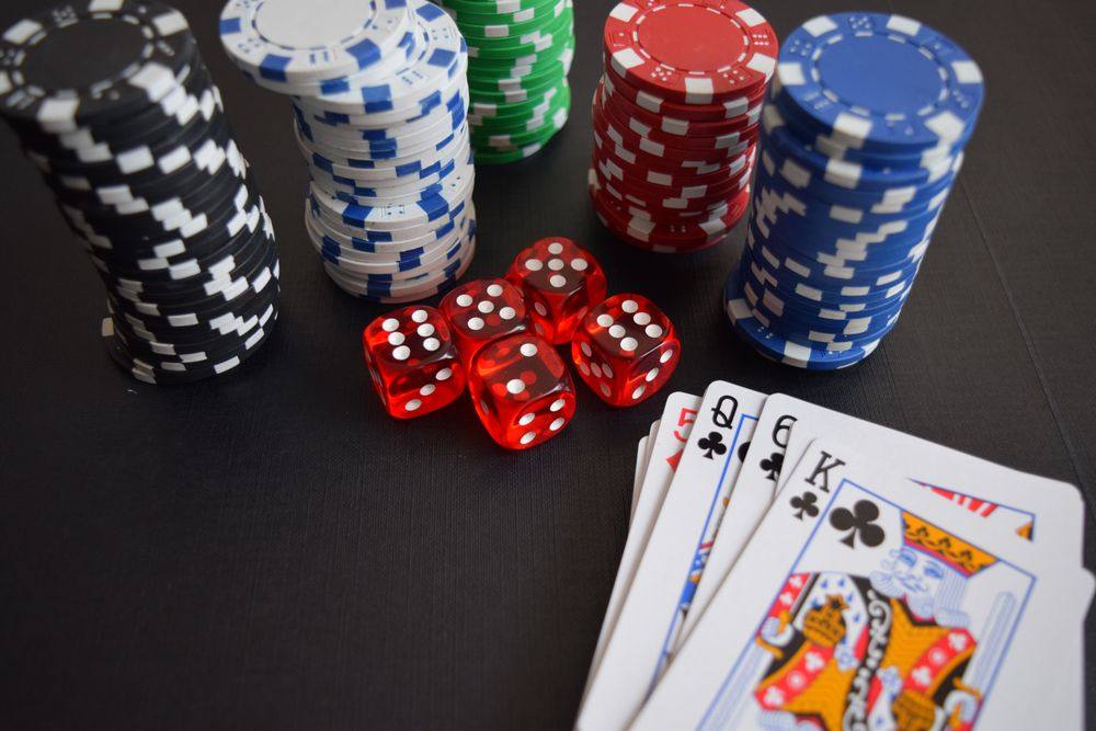 Chip, dadu, dan kartu permainan tersusun di atas meja