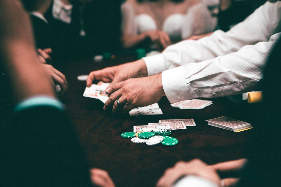 Pemain memegang kartu poker di meja